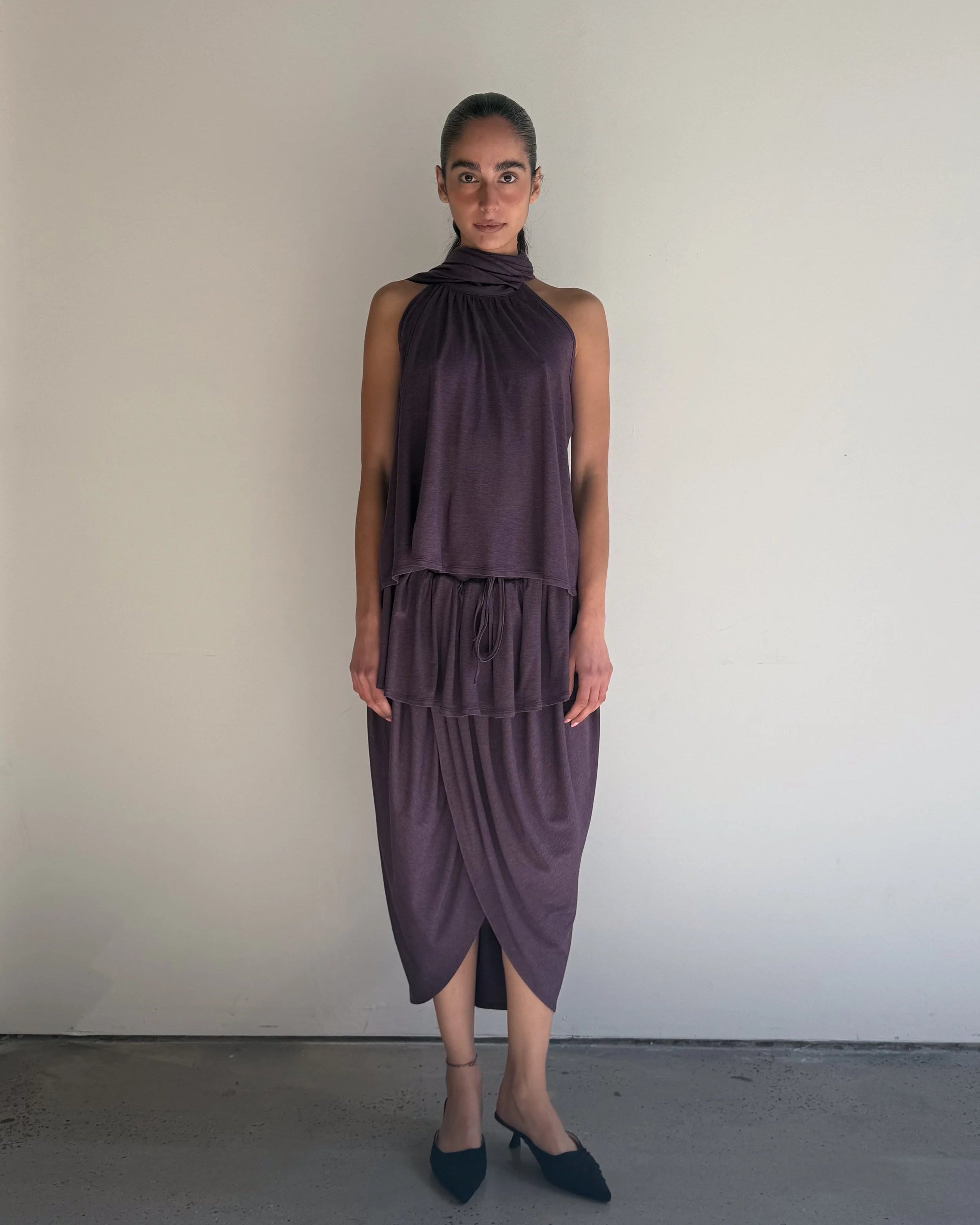 Woman wearing a purple dress against a plain background