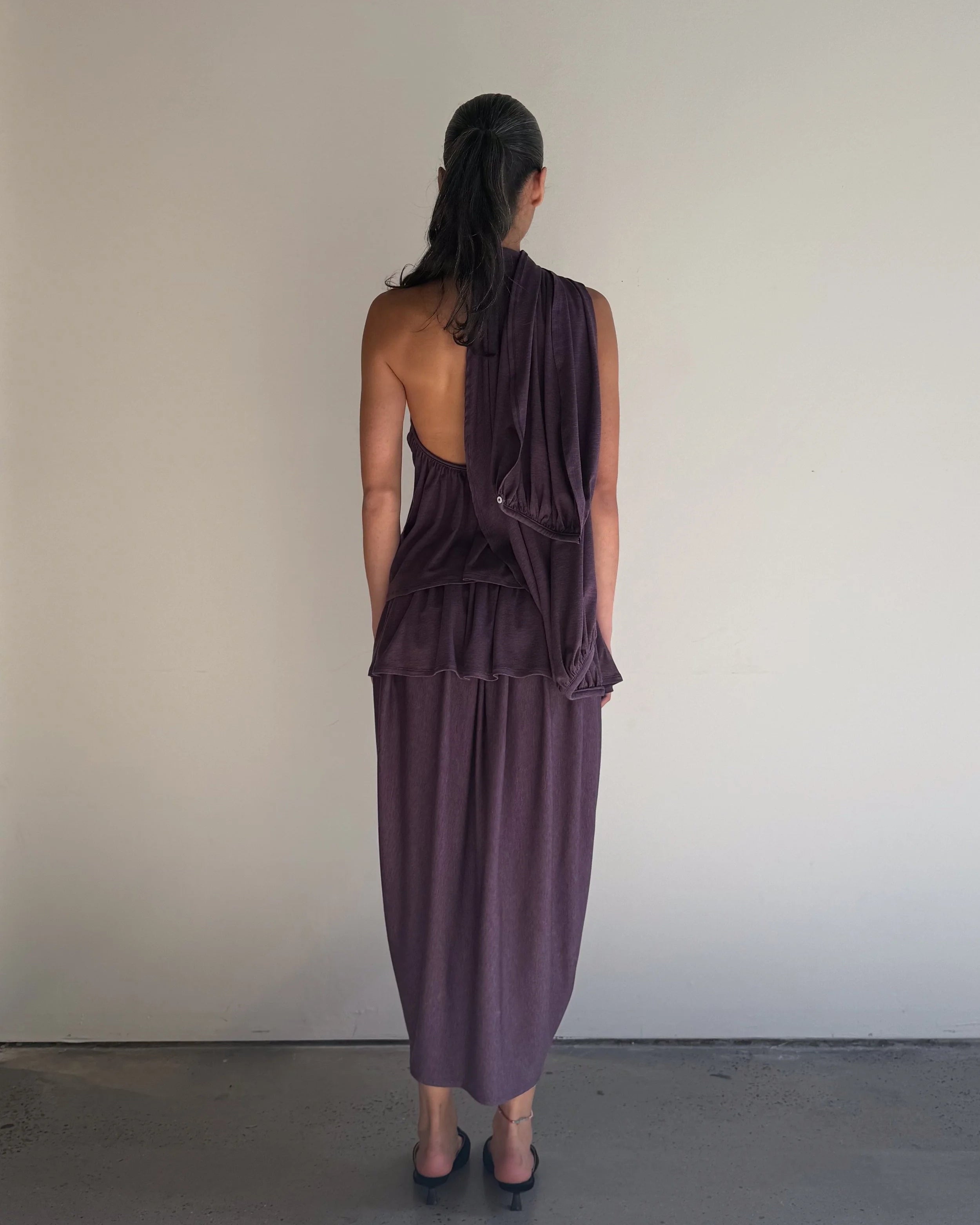Woman wearing a purple dress with a plain background