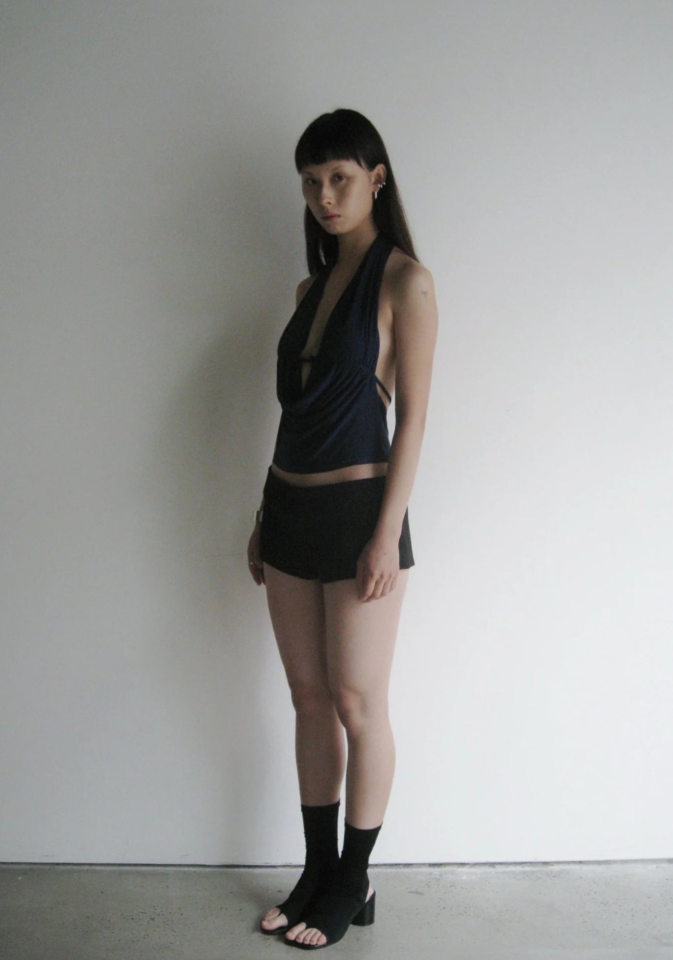 Woman wearing a black outfit against a plain background